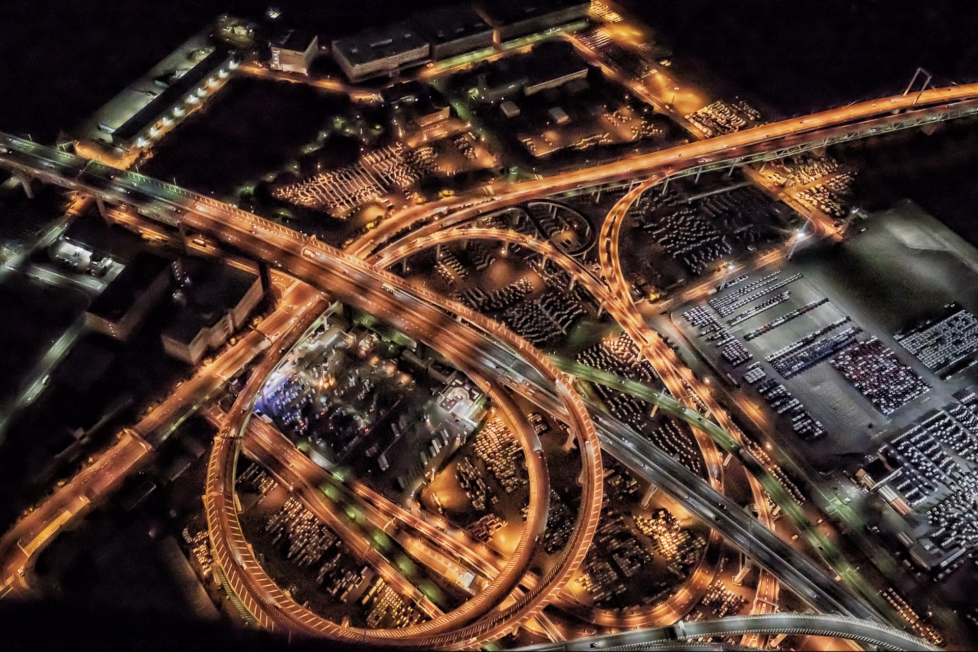 Illuminated aerial view of a complex Shuto Expressway junction in Tokyo at night, showing the challenging highway navigation.